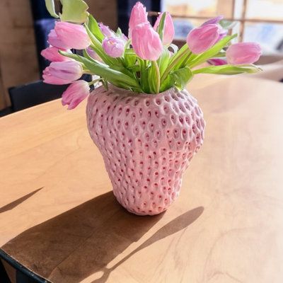 BRING A FRESH TOUCH TO YOUR HOMEIntroducing our Strawberry Ceramic Vase! Inspired by the delightful red fruit, this vase captures the heart of modern design with a twist of nature. Standing proud with its strawberry shape, it promises to give any space a hint of whimsy and charm. | Bay Isle Home™ Strawberry Ceramic Vase, Handcrafted Ceramic Vase, Table Decor, Pink | C100708141 | Wayfair Canada Vase Table Decor, Strawberry Ceramic, Strawberry Planters, Flat Decor, Future Apartment Decor, Plant Vase, Table Vase, Ceramics Pottery Art, Ceramics Projects