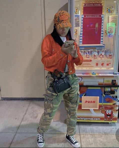 Army And Orange Outfit, Jean Jacket With Cargo Pants, Camouflage Cargo Jeans For Streetwear In Fall, Camo Beanie Outfit, Camo And Orange Outfit, Fall Military Hooded Jacket For Streetwear, Camo Jacket Street Style, Fall Camouflage Streetwear Outerwear, Camo Hats Outfits