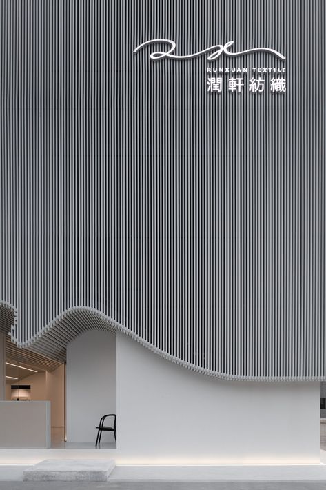 For a textile company in Foshan, China, Rationale International – Masanori Design Studio devised an exterior that recreates the symmetry of yarn on a loom using slender white-toned aluminum bars. Retail Facade, Shop Facade, Interior Minimalista, Building Facade, Facade Architecture, Facade Design, Commercial Design, Facades, Office Building