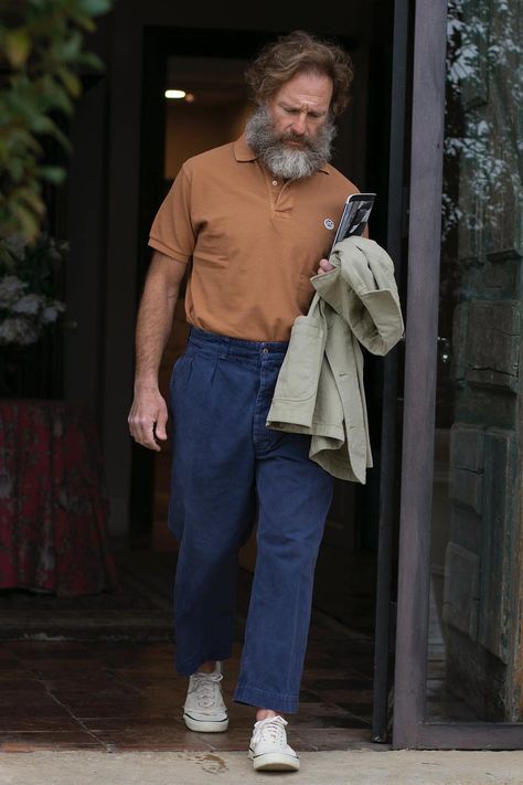 Man wearing blue pleated pants, tucked in brown polo shirt and khaki unstructured jacket with canvas low top sneakers. This image was included in the article: 16 Spanish Fashion Brands All Stylish Men Should Know, on MensFlair.com Spanish Men Style, Polo Shirt Outfit Men Street Styles, Brown Polo Shirt, Brown Polo, Unstructured Jacket, Resort Shirt, Spanish Fashion, Soft Tailoring, Shirt Tucked In