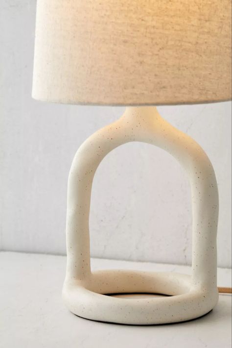 Boho texture brings an inviting touch to this minimalist table lamp. Features a cutout resin base with curving shaping, topped by a subtly angled woven fabric shade. Plugs in to power on. Exclusive to Urban Outfitters. Features - Resin table lamp - Plug-in - Requires 60W Type A bulb - not included - Shade included - Compact fluorescent compatible Content + Care - Resin, fabric - Wipe clean - Imported - Made in compliance with US electrical standards. To use this item outside of the US, pair wi Boho Nightstand, Minimalist Table Lamp, Resin Fabric, Boho Texture, Ceramic Pendant Light, Minimalist Table, Table Lamps Living Room, Minimalist Tables, Side Lamps