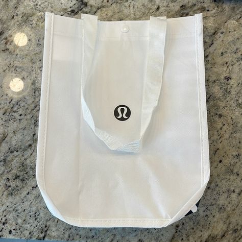 Reusable White Tote With Black Accents Bag From Lululemon. Perfect For Lunches Or Notebooks! Bag Is White Inside And Features A Plastic Snap At The Top Of Bag. Like New, Has Been Unused Since It Brought Some Lululemon Home! Taupe Color In Photos Is For Staging, Not A Part Of Bag. Height: 11” Width: 9” Depth: 4” Handle Peak To Bag Top: 9” Lululemon Lunch Bag Aesthetic, Lululemon Lunch Bag, Freshman Outfits, Pretty School Supplies, Backpack Essentials, Lululemon Bags, Best Lunch Bags, White Tote, Bags Aesthetic