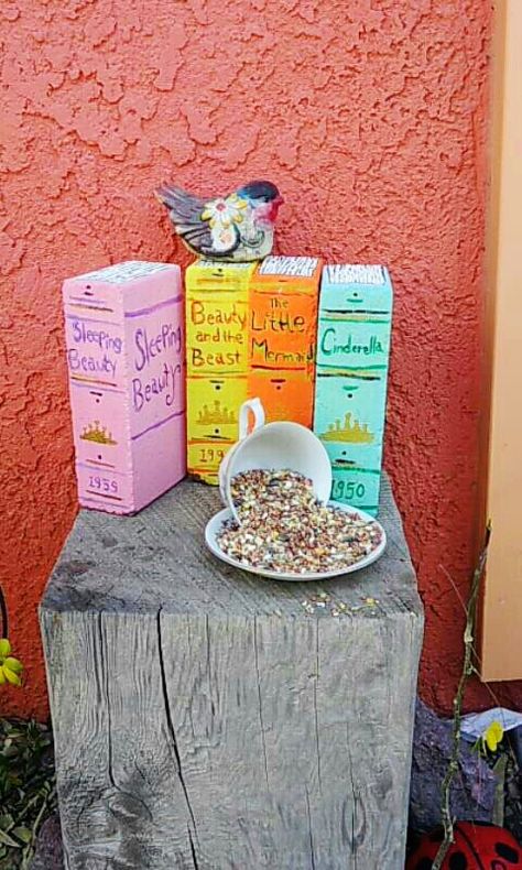 Painted bricks to look like books and a tea cup and saucer for the bird feeder. Painted bricks use acrylic paint Painting Bricks For Garden Ideas, Brick Painted Like Book, Painted Brick Books, Book Bricks Garden, Bricks Painted Like Books, Brick Books Garden, Paint Bricks, Book Bricks, Brick Book