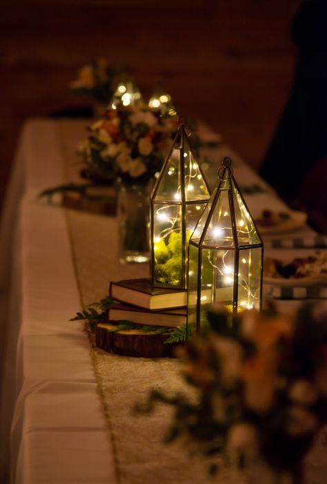 Head table centerpieces. Lanterns and books. Red River Gorge Wedding October 2016. Photo by J.A. Laub Photography. Bookish Wedding Centerpieces, Lantern Fairy Lights Centerpiece, Book Lantern Centerpieces, Lanterns And Books Centerpieces, Lotr Centerpieces Wedding, Fall Book Centerpieces, Book And Lantern Centerpieces, Wedding Lantern Decor Fairy Lights, Whimsical Wedding Table Decor