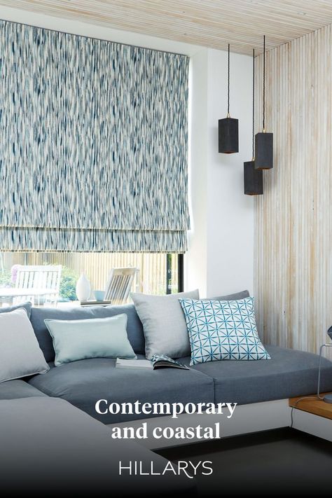 Blue watercolour pattern Roman blind in a contemporary living room with a grey corner sofa, wooden paneled walls and hanging lights from the ceiling. Grey Light Blue Living Room, Roman Blinds Design, Roman Blinds Living Room, Blue Scheme, Blind Design, Blue Roman Blinds, Light Blue Living Room, Hillarys Blinds, Room Blinds