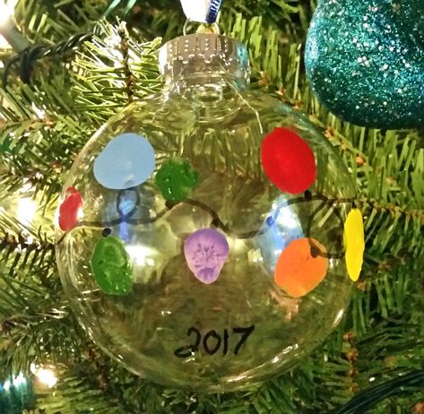 keepsake thumbprint christmas bulb ornament 5 Baby Hand And Foot Prints Crafts Christmas Ornament, Glass Bulb Ornament Ideas, Clear Bulb Ornament Ideas For Kids, Thumbprint Ornaments For Kids, Clear Ornament Ideas For Kids, Clear Bulb Ornament Ideas, Christmas Bulbs Ornaments Diy, Clear Ornament Crafts, Diy Christmas Ornaments For Kids