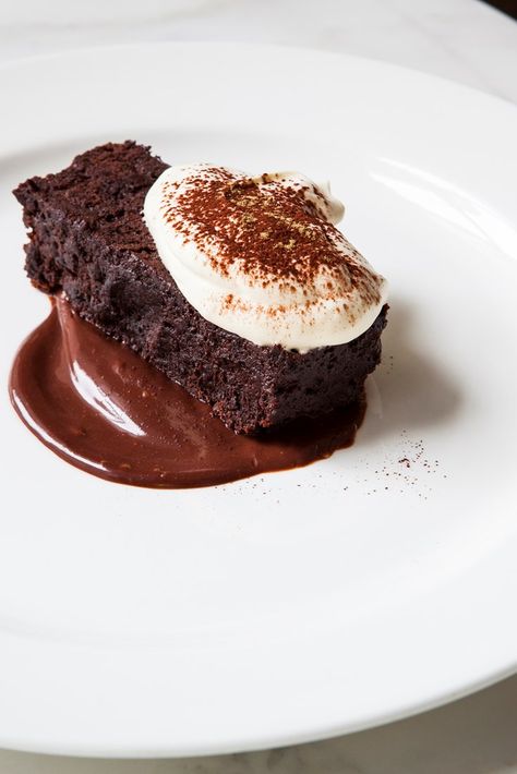 This chocolate cake recipe from Skye Gyngell has a gooey, almost brownie-like texture thanks to the lack of flour in the batter. Paired with a liquorice-infused chocolate ganache and whipped cream, it's a wonderful dish that takes little effort. If you're preparing this for those intolerant or allergic to gluten, use gluten-free flour for dusting the cake tin to ensure there's no cross-contamination. Fancy Brownie Plating, Chocolate Cake Plating, Fine Dining Brownie, Brownies Cake, Brownie Plating, Cake Plating, Chocolate Mousse Cake Recipe, Mousse Cake Recipe, Fine Dining Desserts