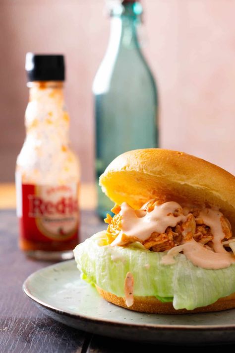 Make homemade buffalo chicken ranch sandwiches in just 30 minutes, for a deliciously spicy treat. Follow the super simple process and make use of a few store-bought ingredients for maximum ease, and enjoy a feast in no time. Chicken Ranch Sandwich, Ranch Sandwich, Homemade Buffalo Chicken, Hand Held Food, Buffalo Ranch Chicken, Buffalo Recipe, Buffalo Chicken Sandwiches, Homemade Buffalo Sauce, Louisiana Hot Sauce