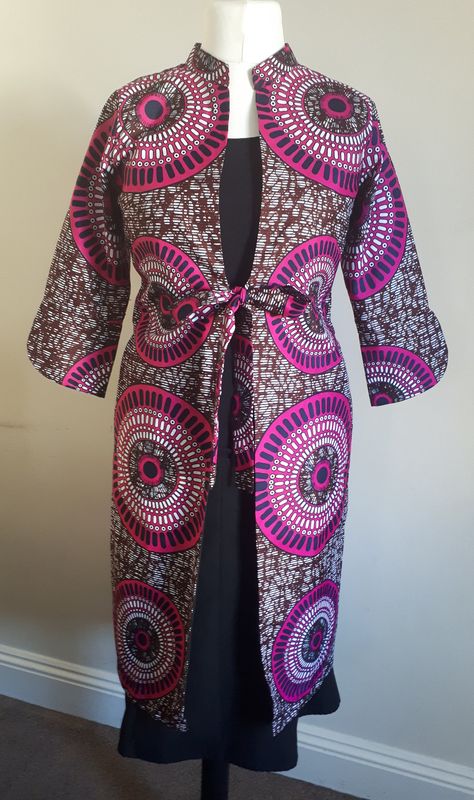 "Women's African Ankara Print Dress Coat. This one of a kind mid length coat is the perfect piece for your spring wardrobe. Fully lined with a vent at the back and 3/4 length sleeves. A stunning pink, black and white geometric print pattern. Generous side pockets. Tie fastening at the waist. This eye catcher can be worn formally or informally. Features Made from premium African print 100% wax print fabric *3/4 Sleeve *Mid Length *Pockets Size: Small Bust: 35 - 36 inches Waist: 28 - 30 inches Len Dress Coats For Women, African Print Coat, Kitenge Fashion, Ankara Jackets, Jacket Outfit Women, African Clothes, African Ankara, Dress Unique, Geometric Print Dress