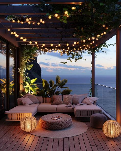 This pin depicts a beautifully designed outdoor lounge area at twilight. The space features a large, L-shaped sectional sofa with soft beige cushions.Hanging above the lounge area are strings of small, warm, globe-shaped fairy lightstwo spherical lanterns with a wicker design emit a warm light, adding to the inviting ambiance. Large Balcony Ideas House, Large Balcony Ideas Terraces, Balcony Fairy Lights, Large Balcony Ideas, Dark House Exterior, Dream Balcony, Apartment Views, Balcony Oasis, Nature Lights