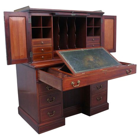 A superb quality 19th century mahogany secretaire desk cabinet, the top section having a brass gallery running along the back and sides, having three moulded and inlaid panels at the front with lovely figuration, the larger middle panel lifting out and sliding into the top to reveal various compartments, then the panels either side being able to unlock and open out to reveal further compartments and mahogany lined drawers, the bottom section consisting of a long single drawer which open out to r