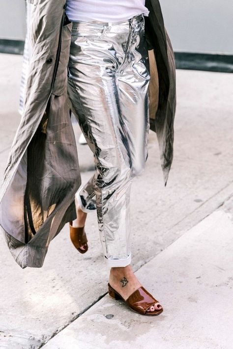 When it comes to metallic pieces we tend to gravitate towards the safer options like bags and shoes. The shiny accessories and pair of sandals, flats, or boots allow us to add some shiny flair without it overwhelming our look. It wasn't until we came across this street style shot from New York Fashion Week earlier this month, that we started considering taking our love for metallics to the next level with a cool pair of silver statement jeans. Flats With Jeans, Sandals With Jeans, How To Wear Flats, Metallic Fashion, Silver Pants, Metallic Jeans, Metallic Pants, Nyfw Street Style, Jeans Outfits