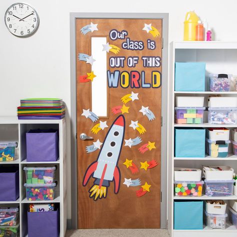 Featuring an image of a rocket ship, blank shooting stars to add student names and the phrase, "Our class is out of this world," these door decorations will motivate students to reach for success as soon as they walk in the door. Give the class an out of this world welcome to start each school day. Includes 30 blank cutouts. Cardstock. (44 pcs. per unit) Sheets, 16" x 24 1/2".  Space Door Decor Instructions Astronaut Door Decorations Classroom, Rocket Classroom Theme, Reach For The Stars Classroom Theme, Beginning Of The Year Door Decorations, Space Theme Classroom Door, Space Door Decorations, August Door Decorations Classroom, Space Classroom Door, Outer Space Classroom