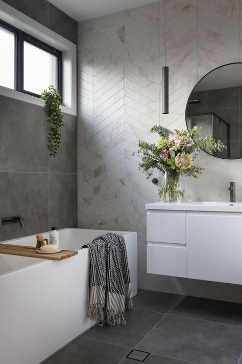 A modern ensuite, with marble look chevron tiles and concrete look floors. Round mirror, free standing bath, floating vanity and gunmetal tap wear. Built by R.E.P Building. Photography by Hcreations. Modern Ensuite, Design Interior Baie, Chevron Tile, Bad Inspiration, Decor Baie, Bathroom Layout, Marble Bathroom, Bathroom Renos, Bath Tub