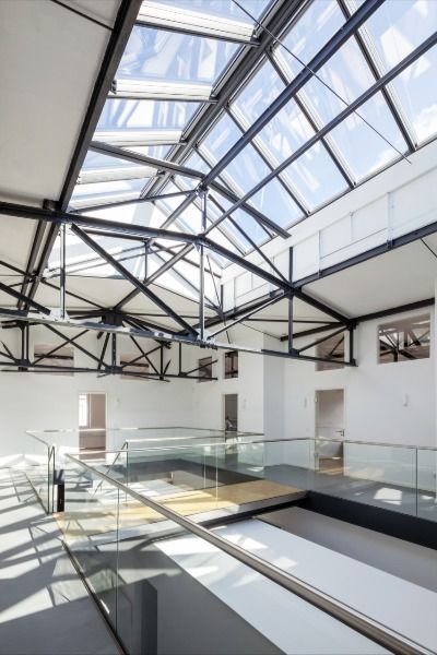 The Old Boiler House in Germany has been transformed from a historic factory hall into a bright office building. 32 Ridgelight modules from Velux Commercial  contribute to a modernised look and ensure optimal daylight in the building. / Architect: Ihre Architekten

#veluxcommercial #architecture #architecturephotography #rooflight #skylight #architectural #office #officedesign #refurbishment #factory #architektur Modern Office Building, Houses In Germany, Bright Office, Skylight Design, Modern Office Space, Arch Architecture, Interior Work, Roof Light, Modern Office