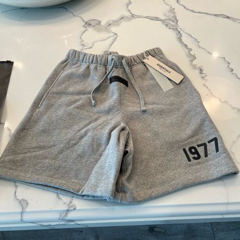 The Fear Of God Essentials Shorts 'Dark Oatmeal' From Ss22 Nod To Designer Jerry Lorenzo's Birth Year, With "1977" Printed In Velvety, Varsity-Style Lettering On The Leg. Cut For A Straight-Leg Fit From Cotton-Rich Jersey, They're Topped With An Elongated Drawstring And Rubberized Brand Patch On The Front. Essentials Shorts Outfit, Jersey Shorts Outfit, Baddies Hairstyle, Essentials Shorts, Essential Shorts, Boys Birthday Outfits, The Fear Of God, Oversize Outfit, Classy Fits