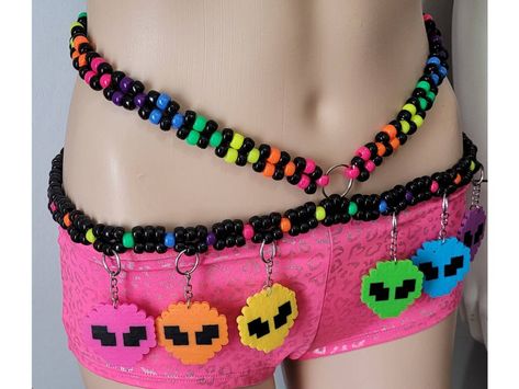 This kandi belt is made with neon pony beads and alien perlers. Glows under blacklight! Includes one kandi belt. Harness sold separately. One size fits most. This item ties in the back & around neck for easy adjusting. This Item is premade and is ready to ship! Perfect for any event! You will get lots of compliments in this unique wearable art! Stand out at your next event! Edm festival  Raves Party  Rave outfit  Festival outfit Pride Mardi gras Rave gift  Rave birthday Glow party Hypercore Outfits, Edc Kandi Ideas, Rave Belt, Kandi Belt, Alien Kandi, Rainbow Rave Outfit, Birthday Glow Party, Rave Birthday, Alien Outfit