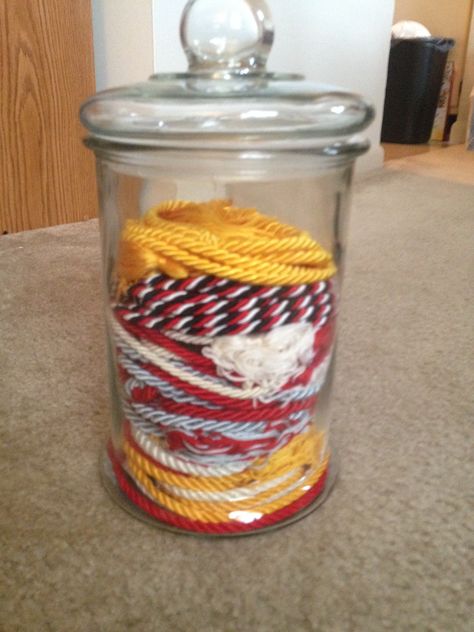 Display honor cords in an apothecary jar. How To Display Graduation Cords, Graduation Cords Display, Graduation Cords Display Cute Ideas, Graduation Cords, Shadow Box Graduation, Graduation Party Desserts, Senior Year Things, Graduation Cap And Gown, Graduation Crafts