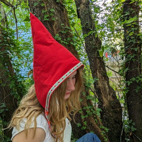 Whimsical and fun handmade pixie hats, the perfect accessory for adding a touch of magic to your winter wardrobe. These unique triangular-shaped hats are made of red cotton corduroy and lined with soft cotton flannel. Reversible and trimmed with playful woven jacquard ribbon ties, these hats are perfect for a Halloween costume or everyday dress up.  The two sets of snaps at the chin ensure a secure fit, with no ties or bows to fuss with. Whether you want to dress up as a fairy, gnome, or elf, th