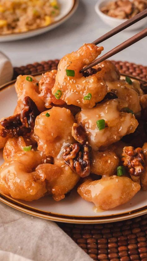 Plate of honey walnut shrimp garnished with green onions, with chopsticks picking up a piece. Honey Walnut Shrimp Panda Express, Walnut Shrimp Panda Express, Walnut Shrimp Recipe, Making Honey, Honey Shrimp, Seafood Delight, Asian Dinner, Asian Dinner Recipes, Walnut Shrimp