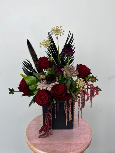 dark red roses, black greens and crodile fern. dark yet fashionable #floral #gothflowers Black Rose Flower Arrangements, Dark Red Floral Arrangements, Goth Flower Arrangements, Dark Floral Arrangements, Vampire Birthday, Black Rose Bouquet, Black Centerpieces, Graduation Flowers, Rose Floral Arrangements