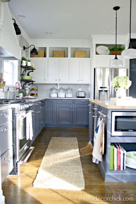 If you have enough room, you can hang items on the wall in the space above your cabinets. Whether it’s framed family photos, mirrors, small macramé creations, or vintage baking Decorating Above Kitchen Cabinets, Two Tone Kitchen Cabinets, Above Kitchen Cabinets, Kitchen Diy Makeover, Diy Kitchen Renovation, Kitchen Cabinets Decor, New Kitchen Cabinets, Kitchen Cabinets Makeover, Chic Kitchen