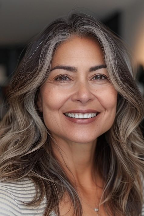 Smiling woman with shoulder-length graying hair and clear skin looking at the camera. Grey Hair Middle Age Women, Long Choppy Layers Thick Hair, Long Layer Hairstyles, Brunette To Grey Transition, Haircuts For Middle Aged Women, 50 Year Old Hairstyles Medium Long Bobs, Medium Long Length Haircut With Layers, Long Grey Hair Over 50 Shoulder Length, Long Hair Over 50