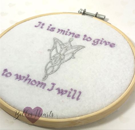 A picture of an embroidery hoop with and embroidery on white felt. The embroidery is of Arwen’s Evenstar with the quote ‘it is mine to give to whom I will’ in a lilac color. Lotr Embroidery Designs, Lotr Embroidery Pattern, Lotr Diy Crafts, Lotr Quilt, Lord Of The Rings Embroidery, Lotr Embroidery, Gifts Made From Wood, Fantasy Embroidery, Lotr Gifts