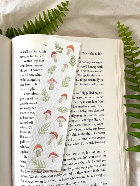 Hand painted to Order  One of a kind hand painted watercolor bookmarks, Mushroom. These book marks are a perfect gift for a loved one, yourself or for any book lover. They can be customized and make a great gift for graduation, summer reading, teachers and end of the year gifts. The bookworms, book clubs and avid readers will love these laminated bookmarks!  All bookmarks are painted to order so the image and color may vary slightly due to the paint on demand method.  Message me for custom colors and large party favor orders! Order includes: 1 Bookmark approximately 1.5 x 6  Painted on sturdy watercolor paper and laminated  Orders will ship in 2-7 business days Please Contact for Options to customize your order (Customizing is not included in the price) - Add name  - Add Initial Follow Us Mushroom Bookmark, Mushroom Theme, Bookmark Watercolor, Painted Bookmarks, Mushroom Aesthetic, Watercolor Mushroom, Aesthetic Mushroom, Fantasy Mushroom, Art Mushroom