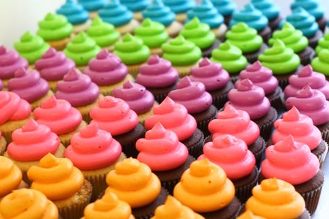 Dozens of neon frosted cupcakes for a kid's graduation party!  After  testing various brands of food coloring, AmeriColor electric gels created  the brightest colors. Flower Cake Buttercream, Cupcake Assortment, Neon Cupcakes, Neon Cakes, Neon Food, Frosted Cupcakes, Cupcake Cones, Glow Birthday Party, Holi Party