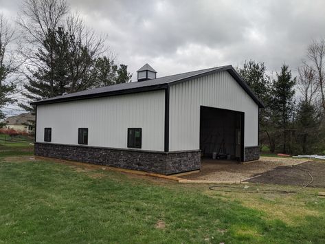 40x32 Pole Building shell. Black and White black windows and stone wainscoting White Metal Building With Black Trim, Black And White Metal Building, Gray And Black Metal Building, Black And White Garage, Metal Building Garage, White Metal Building, Black And White Barndominium, Black Metal Barn, Black And White Pole Barn