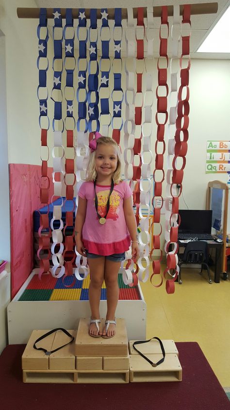 PreK Olympics unit: Olympic medal stand with paper-chain American flag hanging from ceiling in background Hanging From Ceiling, Medal Stand, Paper Chain, Flag Hanging, Olympic Medals, Paper Chains, How To Hang, Ffa, Event Themes