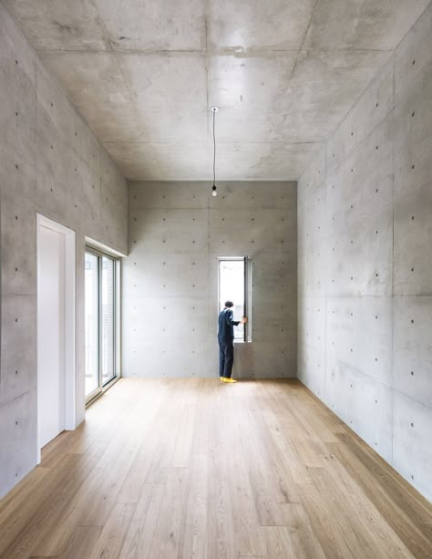 The inside of this building is finished minimally with reinforced concrete walls left mainly exposed throughout. Just a few are plastered and painted white. Concrete Home Interior, Concrete Walls Interior, Concrete Interiors, Concrete Ceiling, Wood And Concrete, Concrete Houses, Concrete Architecture, Concrete Walls, Concrete Home