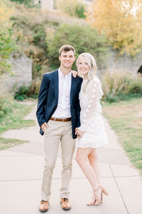 Young couple in formal outfit at fall engagement photo session Groom Engagement Party Outfit, Purple Dress Couple Outfit, Engagement Pictures Mens Outfit, Classic Engagement Photos Outfits, Engagement Photos Outfits Elegant, Dressy Engagement Outfits, Neutral Engagement Outfits Fall, Male Engagement Outfits, Engagement Photos Mens Outfits