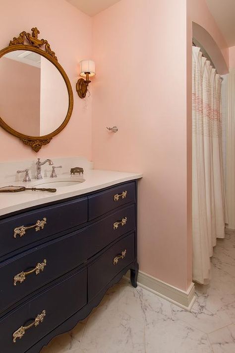 Some posh pink walls certainly cheer up a dark blue kids bathroom fitted with a french repurposed washstand topped with a white quartz countertop A gold French mirror adds dainty appeal along with ornate gold handles on the black washstand. Bathroom With Pink Walls, Navy And Pink Bathroom, Blue Kids Bathroom, Blush Bathroom, Pink Tile Bathroom, Pink Bathrooms, Small Bathroom Wallpaper, Navy Bathroom, Blue Bathroom Tile