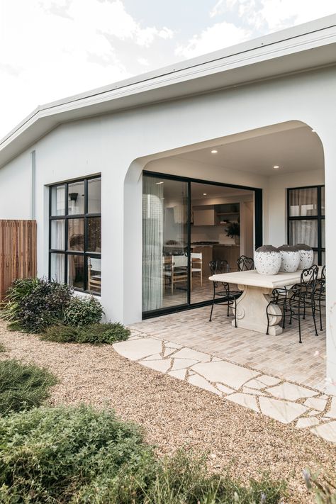 This gravel garden embraces the European style of the home, creating a sense of rustic charm. This garden features an undefined decorative pebble path with drought-tolerant plants like lavender and rosemary, and warm, subtle colour palettes that create a serene, timeless feel. This style offers a low-maintenance yet sophisticated outdoor space that feels both inviting and effortlessly chic. Courtyard Gravel Garden, French Courtyard Garden Ideas Pea Gravel, Pebble Courtyard, White Pebble Courtyard, Compacted Gravel Pathway, Pebble Path, Cloud Pruning, Lavender And Rosemary, River Pebbles