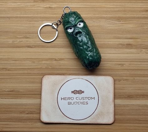 Meet the Not So Positive Pickle, a quirky and comically grumpy addition to your keychain collection! Handcrafted from high-quality polymer clay, this keychain features a sour-faced pickle that's sure to bring a smile (or a smirk) to your face.#keyring #keychains #positivity #supportsmallbusiness #clayart #pickle #grumpypickle #grumpy Pickle Keychain, Positive Pickle, Steampunk Robots, Lanyard Bracelet, Keychain Collection, Clay Keychain, Poly Clay, Beaded Lanyards, Paracord Bracelets