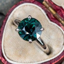 This gorgeous teal sapphire engagement ring is centered with a round brilliant cut no heat sapphire, weighing 4.21 carats, in a four-prong setting. The ring measures 9.7mm at the top, rises 9.8mm above the finger, tapering to 2.0mm wide and 1.5mm thick at the base of the shank. The ring is currently a size 5.5 and we offer complimentary sizing to fit. Solitaire Sapphire Engagement Ring, Engagement Rings 4 Carat, Sapphire Solitaire Engagement Ring, Solitare Engagement Rings, Gem Engagement Rings, Sapphire Engagement Rings, Sapphire Solitaire Ring, Blue Engagement Ring, Round Sapphire