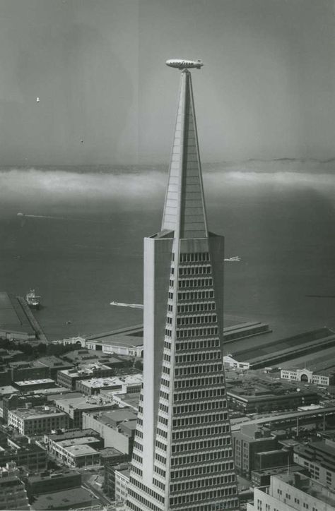 In this photo, the Goodyear Blimp appears to be docked atop the Transamerica Pyramid in San Francisco, with the fog rolling in from the ocean. The photo was at the right place at the right time, July 5, 1991. Goodyear Blimp, Transamerica Pyramid, Pyramid Building, Sao Francisco, History Projects, The Fog, Famous Landmarks, Brutalism, Right Time