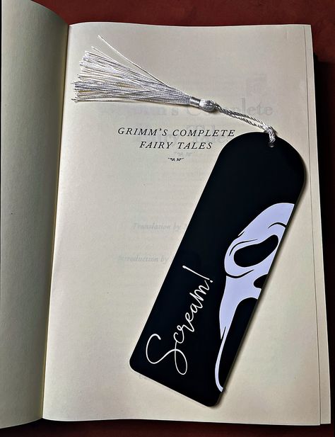 What's your favourite scary book?  Mark your page with this ghost face bookmark, the perfect gift for any horror bookworm. Handmade to order  using high quality, 3mm thick laser cut acrylic layered with permanent vinyl design and a colour co-ordinated tassel.   The design is on one side only, the other side will be left blank.  -----Size-----  15cm length x 5cm width x 3mm depth I'd love to see your photos so please tag us @helheimhomewares on Instagram.   Free delivery included -----Custom colo Science Bookmarks Diy, Book Mark Inspo Aesthetic, Cool Book Mark Ideas, Book Mark Handmade, Scream Bookmark, Thriller Bookmarks, Book Marks Design, Scary Bookmarks, Designs For Bookmarks