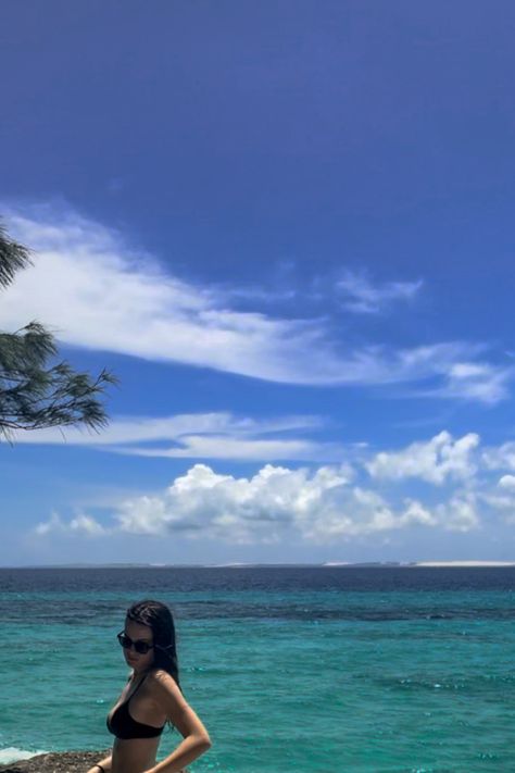 Brunette girl with black bikini and black sunglasses standing on the beach, next to the ocean. Standing sideways with her arm bent and it forms a triangle between her and her body. The ocean is a mix of turquoise and blue and you can see and island in the back ground. It is a clear days with a few clouds in the sky Rocky Beach Aesthetic, South Of France Aesthetic, Swimming Aesthetic, Aesthetic Beach Pictures, Aesthetic Summer Vibes, French Beach, Beach Memories, European Summer Aesthetic, Poses By Yourself