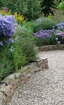 Dry stone wall forming raised borders - a good way of using up the pile of stones! Cerca Natural, Raised Borders, Stone Walls Garden, Gravel Patio, Stone Patio, Budget Garden, Areas Verdes, Dry Stone Wall, Gravel Garden