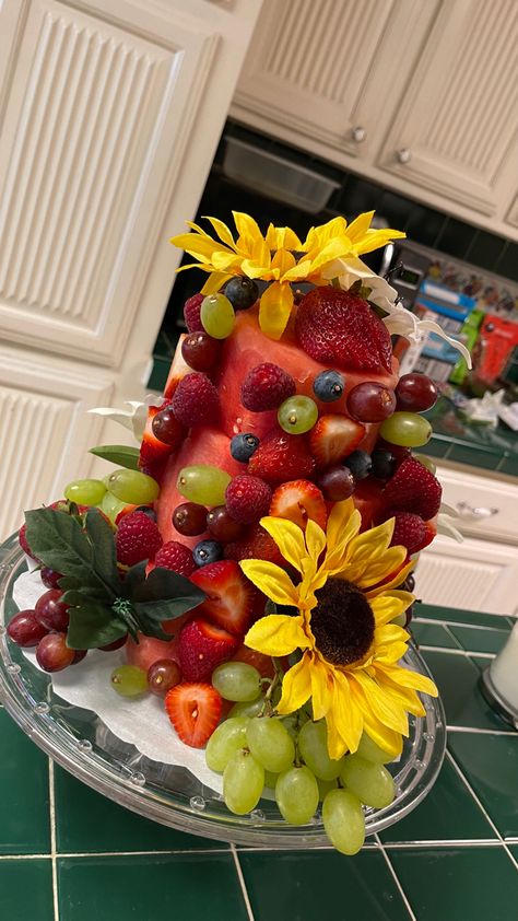 I made my brother a fruit cake for his Birthday! All you need is one watermelon, fake flowers (or real edible flowers, an assortment of your favorite fruits, and a lot of toothpicks 🥰. You’ll cut your watermelon into three layers. If you want more layers then you’ll need more watermelons. Don’t forget to wash your fruits and fake flowers before using them :). 💖🍉🎂✨ Watermelon Cakes, Cake For His Birthday, Cakes With Flowers, Fake Fruit, A Fruit, Edible Flowers, Fruit Cake, Fake Flowers, My Brother