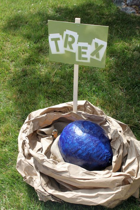 The actual results... T-Rex nest: One paper mache balloon, kraft paper nest, and a "baby T-Rex" nestled by the egg. Dinosaur Nest, Paper Mache Balloon, Dinosaur Classroom, Paper Nest, Jurassic Park Party, Birthday Party At Park, Reptile Party, Dinosaur Party Decorations, Dino Park