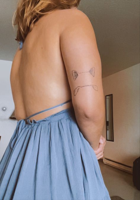 girl in blue dress facing away. back of the left arm has two pairs of ears on top of one another about two inches apart. top is a pair of cat ears and bottom is a pair of dog ears. Tattoos To Honor Pets, Cat Honor Tattoo, Dog Tattoos German Shepherd, Cat And Dog Ears Tattoo, Animal Ears Tattoo, Pet Tattoo Placement, Dog Ear Tattoo Back Of Arm, Dog And Cat Outline Tattoo, Pet Nose Tattoo