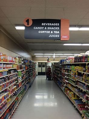 This aisle sign in a grocery store is an example of good signage. It is in the middle of the aisle clear for both sides to see whatof the sign says. It also gives a general idea what the aisle contains. Grocery Store Aisle, Grocery Store Design, Store Signage, Outdoor Signage, Store Design Interior, Visual Merchandising, Store Decor, Retail Store, Sign Design