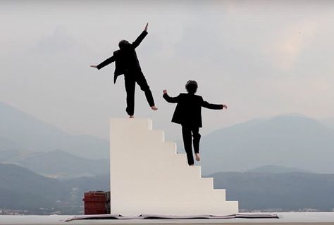 Did you hear the one about two men, a set of stairs and a trampoline? Appearing on a white stage on a hilltop at the Bastille in Paris, these components can be seen in a performance directed by actor, dancer and acrobat Yoann Bourgeois. ‘Cavale’ presents a refined, minimal circus act that reveals itself as a play with repetitive, dizzying movements and vertigo. The video clip portrays two men repeatedly walking up stairs, pausing to observe the landscape in front of them from the top, before ... Drawing Stairs, Stairs Drawing, Walking Stairs, Yoann Bourgeois, People Top View, How To Draw Stairs, Walking Up Stairs, Stair Art, Up Stairs