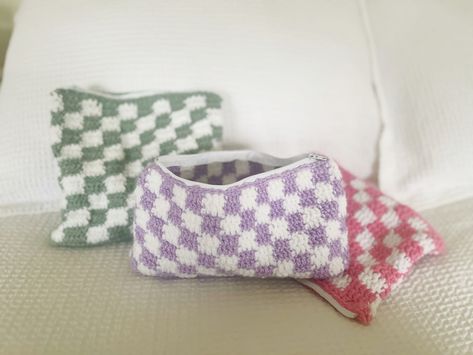 "These checkered crochet pouches are perfect for toiletries, makeup, & all your cosmetic needs. They can also be used as pencil cases, a travel essential, and much more!  These pouches are 9\" in length and come in widths of either 7\" and 5 1/2.\" All zippers are white nylon and sewn with white thread." Crochet Makeup Bag, Crochet Pouches, Checkered Crochet, Pencil Case Pattern, Crochet Pencil Case, Cute Pencil Pouches, Crochet Purple, Crochet Cat Hat, Crochet Pouf