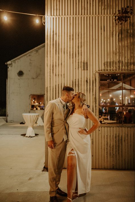 Moody photo with Bride and Groom kissing in reception / second wedding dress with garter peaking out First Kiss Wedding With Guests, Dress With Garter, Intimate Wedding Just Bride And Groom, Wedding Ceremony Pictures First Kiss, Groom Taking Off Garter Wedding Photos, Second Wedding Dress, Bride And Groom Kissing, Second Wedding, Wedding Vibes