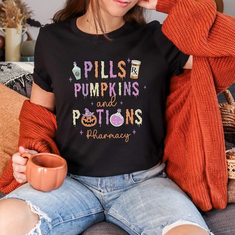 Get ready to be OBSESSED with your new Halloween Pharmacy shirt. This is the perfect Halloween Pharmacist Shirt to wear during the spooky season!  ✦KEY FEATURES:: ✺ 100% Airlume combed and ringspun cotton (fiber content may vary for different colors) ✺ Light fabric (4.2 oz/yd² (142 g/m ✺ Retail fit ✺ Tear away label ✺ Runs true to size * S I Z I N G * ✺ Models are wearing size medium  ✺ Sizing is unisex so runs like men's, though not overly large ✺ Most women find their typical size works best, since they are meant to fit a touch loose ✦ CARE INSTRUCTIONS:: Machine wash: warm (max 40C or 105F); Non-chlorine: bleach as needed; Tumble dry: low heat; Iron, steam or dry: medium heat; Do not dryclean. ✦ DISCLAIMER: Product color may slightly vary due to photographic lighting sources or your mon Pharmacy Halloween, Pharmacy Graduation, Pharmacist Shirt, Tech Outfit, Pharmacist Gift, Pharmacy Tech, Medical School Motivation, Crazy Hats, Tech Shirt